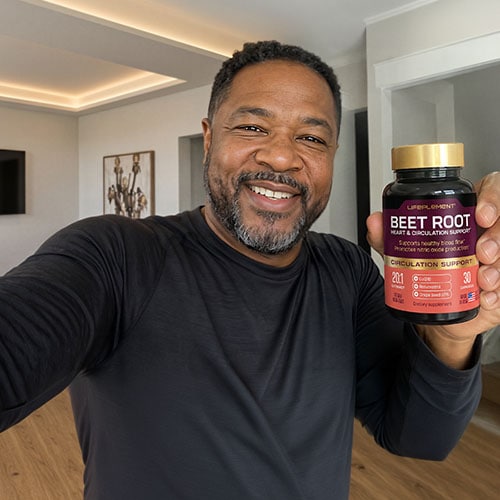 Man holding LIFEPLEMENT Beet Root supplement bottle, smiling at camera.