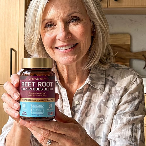 Woman holding LIFEPLEMENT Beet Root Supplements jar in kitchen.